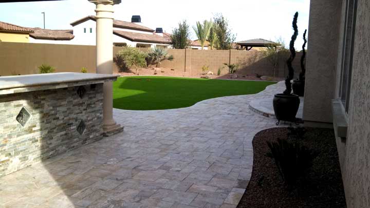 synthetic grass with travertine pavers